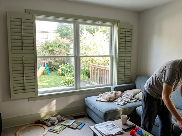 Bi-pass sliding shutters partly open on a wide window in Chatelaine Village