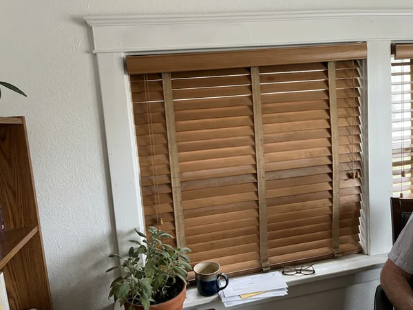 Wood blind slats with decorative cloth tapes and a matching valance return
