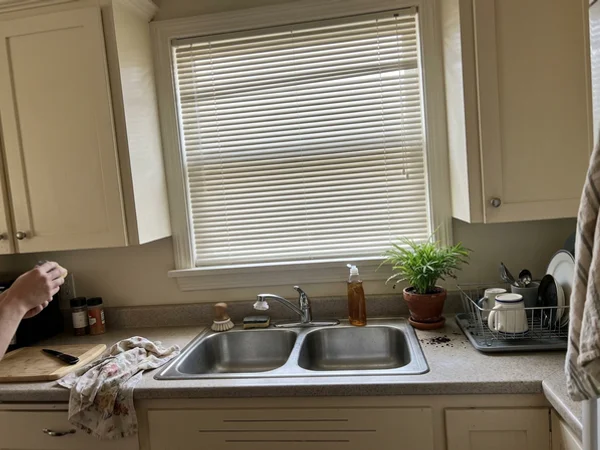 Cream aluminum blind matching cream cabinets in a Beacon Hill kitchen