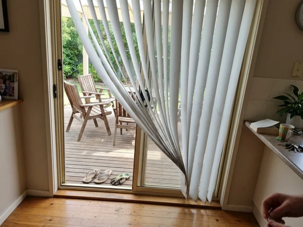 Curved S-vane vertical blinds tilted half open on a Nepean patio door