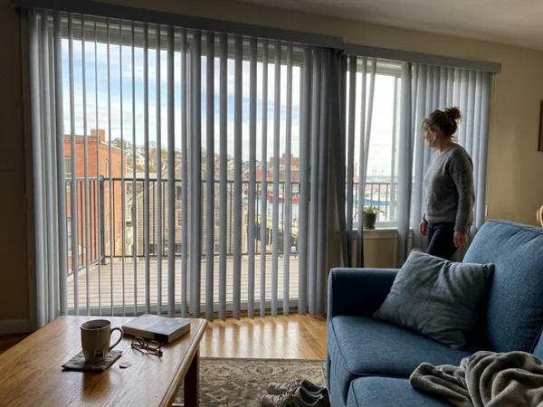 Grey fabric vertical blinds on a wide window wall in a Gloucester condo