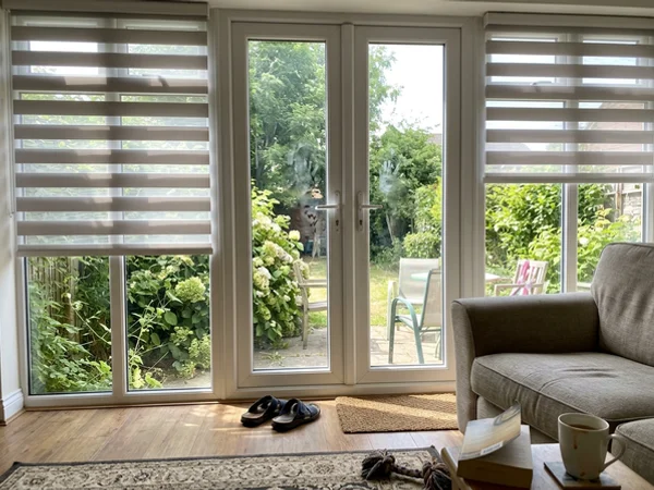 Motorized zebra blinds half lowered on south-facing windows in a Gloucester home
